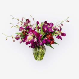 Purple orchid bouquet in a clear glass vase