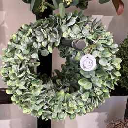 Round wreath of dense green foliage on a display stand