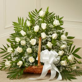 White rose basket arrangement with baby's breath and a white ribbon