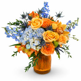 Bouquet of orange and blue flowers in an amber glass vase