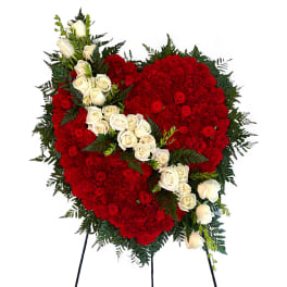 Heart-shaped red floral spray with white roses on a stand