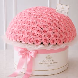 Large dome of pink roses in a round hatbox with a pink ribbon