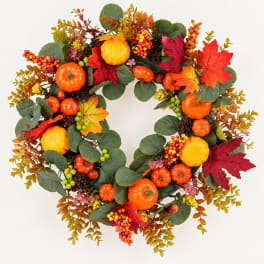 Autumn wreath with pumpkins, berries, and colorful leaves