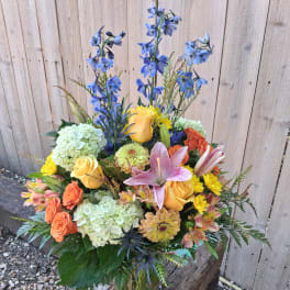 Colorful mixed bouquet with roses, lilies, hydrangeas, and blue delphinium