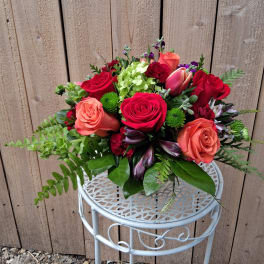 Bouquet of red and coral roses with mixed greenery