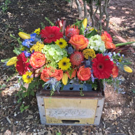 Bright mixed flower arrangement in a rectangular container outdoors