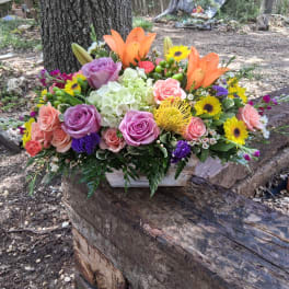 Colorful mixed flower arrangement in a rustic wooden box