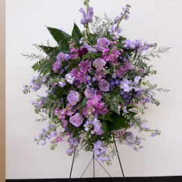 Lavender and pink floral standing arrangement on a black easel