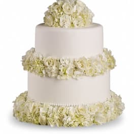 Three-tier white cake adorned with ivory and cream flowers on each tier