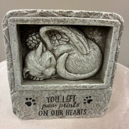 Stone memorial with a sleeping cat relief and paw prints