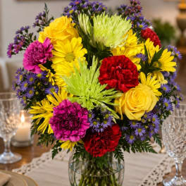 Colorful mixed bouquet in a clear glass vase on a table