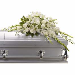 White floral spray arranged on a silver casket