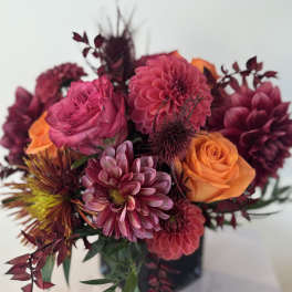 Bouquet of pink and orange flowers in a dark vase
