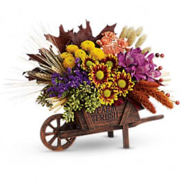 Fall flower arrangement in a wooden wheelbarrow container