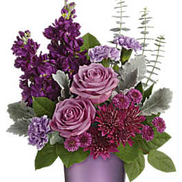 Purple and pink floral arrangement in a lavender vase