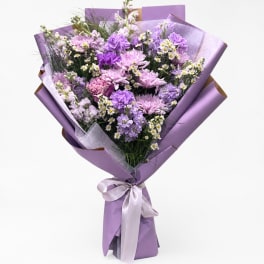 Lavender bouquet of mixed purple flowers wrapped in purple paper
