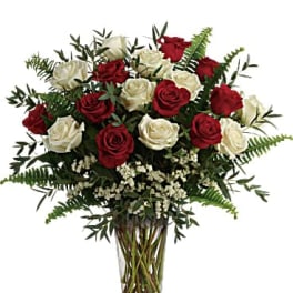 Red and white roses in a clear glass vase