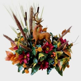 Autumn floral arrangement with a deer figurine and tall grasses