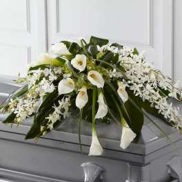 White floral casket spray with calla lilies and orchids