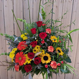 Tall mixed bouquet with red roses, yellow sunflowers, and orange gerbera daisies