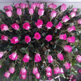 Large arrangement of pink roses laid out in a dense oval shape