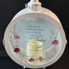 Round memorial lantern with a candle and floral design on the glass