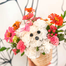 Basket of pink and white flowers with a ribbon tied on top
