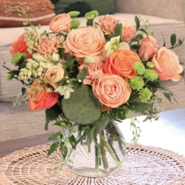 Peach and coral rose bouquet in a clear glass vase