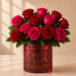 Red and pink roses arranged in a heart-patterned red vase