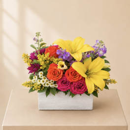Colorful flower arrangement in a white rectangular box