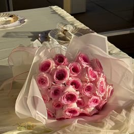 Bouquet of pink roses wrapped in pale paper