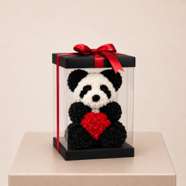 Panda-shaped floral gift in a clear box with a red ribbon and heart