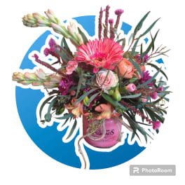 Bright pink and peach mixed flower arrangement in a pink jar-style vase