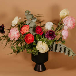 Mixed ranunculus bouquet in a black vase