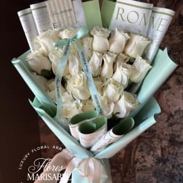 Bouquet of white roses wrapped in pale blue paper with ribbon