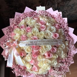 Large bouquet of pink and cream roses with pink baby's breath and a ribbon