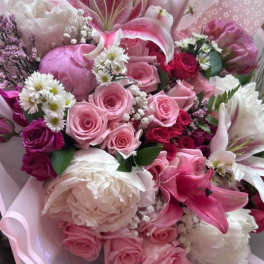 Pink and white bouquet with roses, lilies, and peonies wrapped in pastel paper