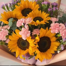 Bouquet of sunflowers and pink carnations with purple filler flowers