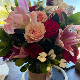 Bouquet of pink lilies and roses in a wrapped vase