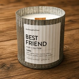 A scented candle in a ribbed metal tin labeled Best Friend