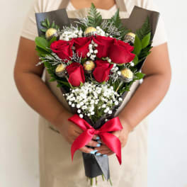 Bouquet of red roses with white baby's breath and gold-wrapped chocolates