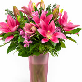 Pink lilies arranged in a tall pink vase