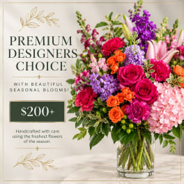 Mixed bouquet in a clear glass vase with roses, lilies, and purple blooms
