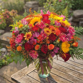 Bright mixed bouquet of roses and daisies in a glass vase
