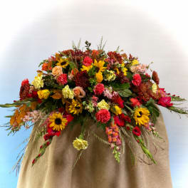 Large mixed bouquet with sunflowers, roses, and carnations in warm fall colors
