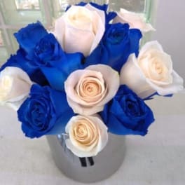 Blue and white roses arranged in a clear vase