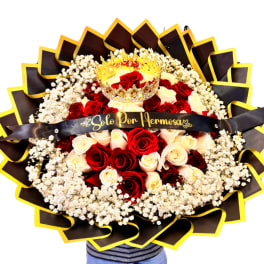 Round bouquet of red and cream roses with a crown topper and black ribbon