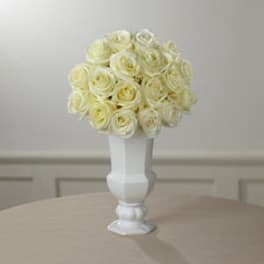Cream rose bouquet in a white pedestal vase