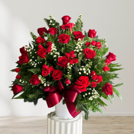 Large bouquet of red roses with white filler flowers in a white vase