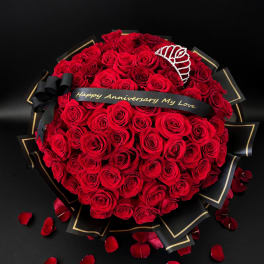Heart-shaped bouquet of red roses with a black anniversary ribbon and tiara
